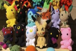 A group of crocheted pokemon toys in a box.