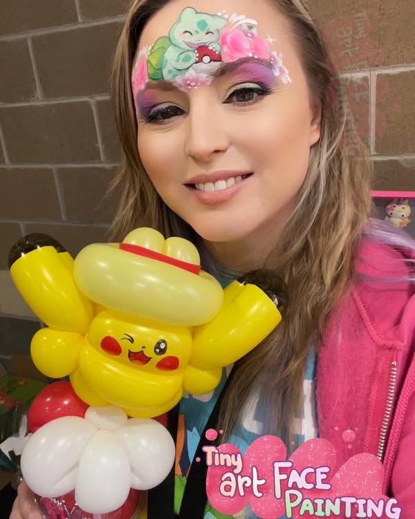 Smiling woman with face painting holds a Pikachu balloon. Text reads “Tiny Art Face Painting.”.