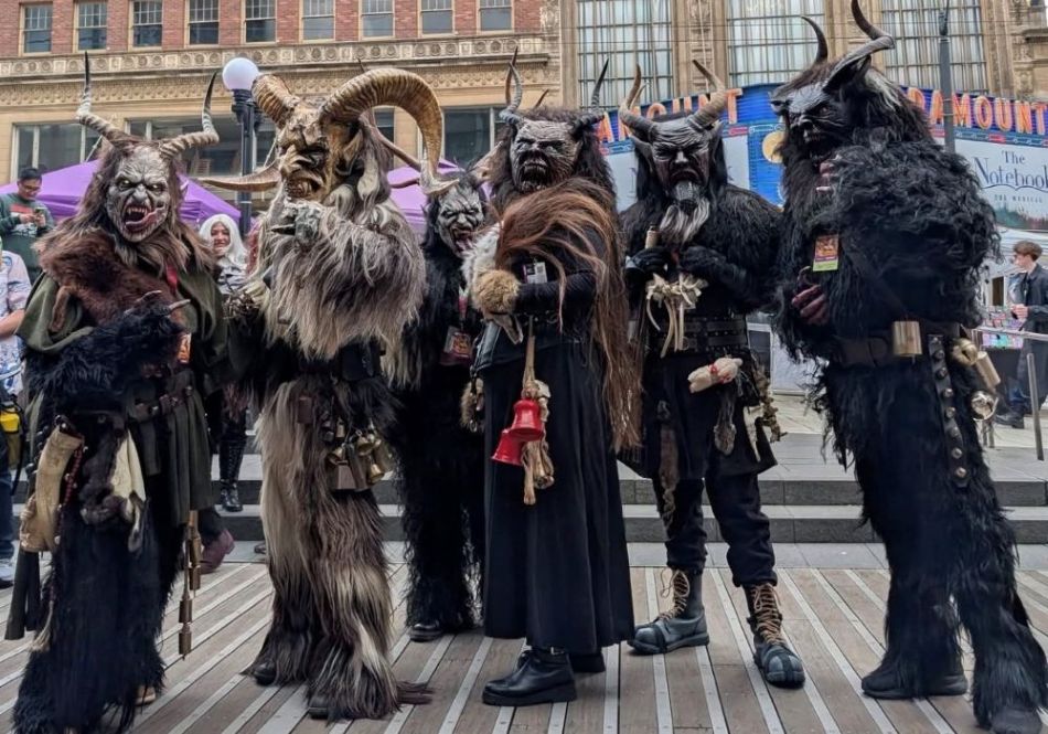 Costumed Krampus Bremerton participants gather outdoors at the festival, pausing for a quick group selfie.