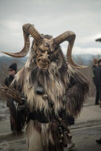 Person in a detailed, horned Krampus Bremerton costume with fur, fangs, and dark, twisted features outdoors.