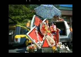 Skeletons dressed in costumes sit in a decorated coffin outside a hearse, with "HEARSES" above them.